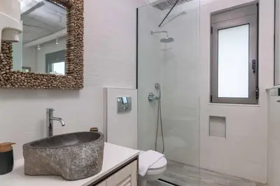 a bathroom with a sink and a toilet and a mirror at Villa Krini Myth in vlicha