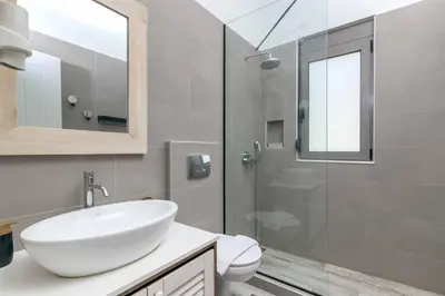 a bathroom with a sink and a glass shower at Villa Krini Myth in vlicha