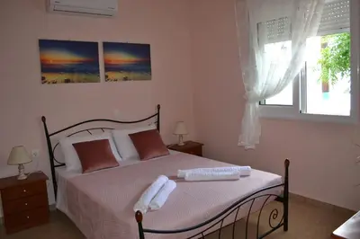 a bedroom with a bed with two towels on it at GALINI STEGNA BEACH in Archangelos