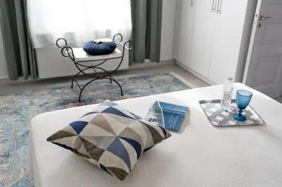 a white bed with a pillow and a tray on it at Beautiful Neoclassical House in Rhodes town in Rhodes Town