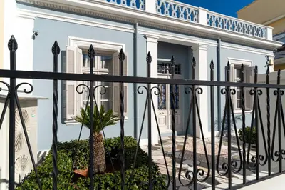 a white house with a black fence at Beautiful Neoclassical House in Rhodes town in Rhodes Town