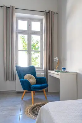 a room with a blue chair and a desk and a window at Beautiful Neoclassical House in Rhodes town in Rhodes Town