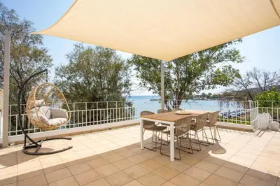 a table and chairs on a patio with a view of the water at Salty Beach Front House Faliraki in Faliraki