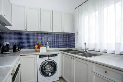 a kitchen with a washing machine and a sink at Salty Beach Front House Faliraki in Faliraki
