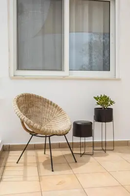 a chair and two stools in front of a window at Salty Beach Front House Faliraki in Faliraki