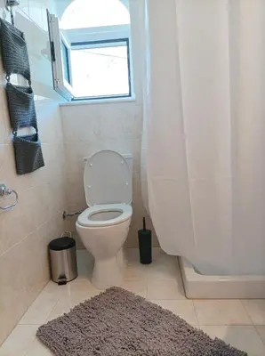 a bathroom with a toilet and a window and a shower at Home Away From Home in Ixia