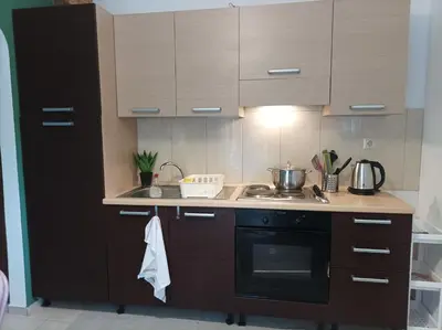 a kitchen with wooden cabinets and a stove top oven at Home Away From Home in Ixia