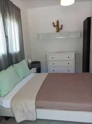 a bedroom with a bed and a cross on a shelf at Home Away From Home in Ixia