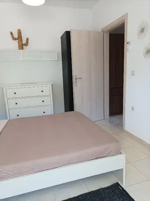 a white bedroom with a bed and a dresser at Home Away From Home in Ixia