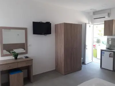 a living room with a television on a white wall at Pefki Irish Seaview in Pefki Rhodes