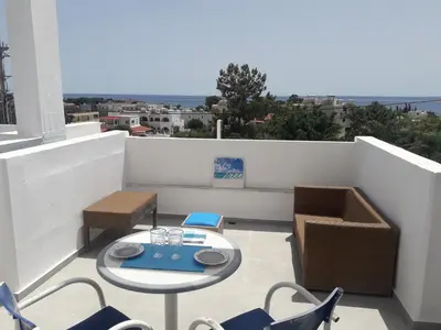 a patio with a table and chairs on a balcony at Pefki Irish Seaview in Pefki Rhodes