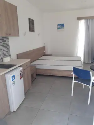 a bedroom with a bed and a table and a chair at Pefki Irish Seaview in Pefki Rhodes