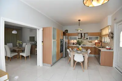 a kitchen and dining room with a table and chairs at Eva's Garden House in Ialyssos