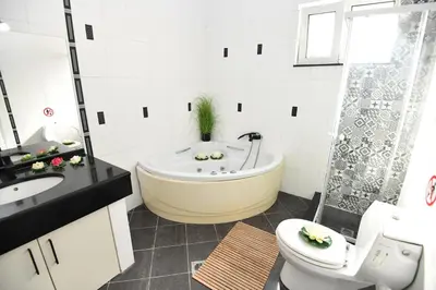 a white bathroom with a tub and a toilet at Eva's Garden House in Ialyssos