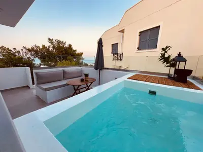 a swimming pool in the backyard of a house at Theros Luxury Apartment in Archangelos