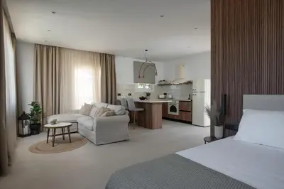 a bedroom with a bed and a living room and a kitchen at Theros Luxury Apartment in Archangelos