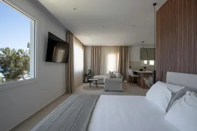 a bedroom with a bed and a living room at Theros Luxury Apartment in Archangelos