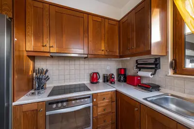 a kitchen with wooden cabinets and a stove top oven at Evilion Villa in Gennadi