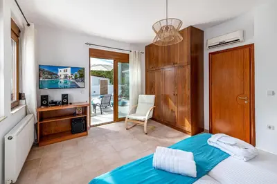 a bedroom with a bed and a desk and a television at Evilion Villa in Gennadi