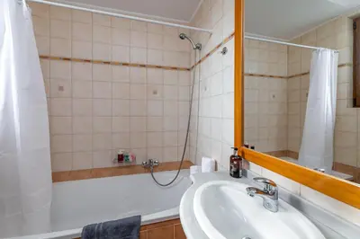 a bathroom with a tub and a sink and a mirror at Evilion Villa in Gennadi