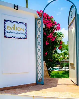 an open door to a white building with pink flowers at Evilion Villa in Gennadi