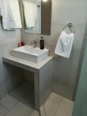 a bathroom with a white sink and a mirror at Stonegarden Studios in Faliraki