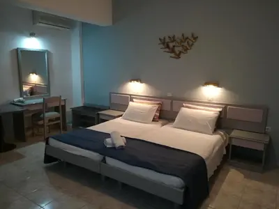 a bedroom with a bed and a desk and a mirror at Stonegarden Studios in Faliraki
