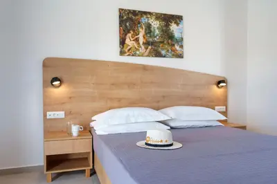 a bed with a hat on top of it at Domus Oliva Villas in Haraki