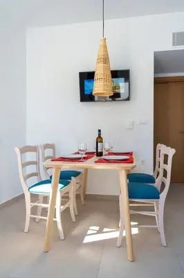 a dining room table with chairs and a bottle of wine at Domus Oliva Villas in Haraki