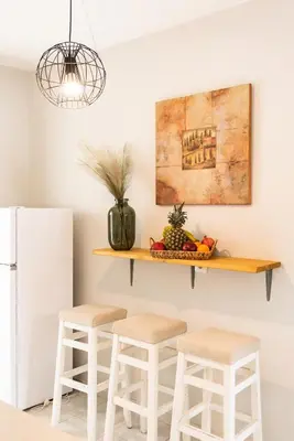 a kitchen with a shelf on the wall with stools at City Center Elite Suite in Rhodes Town