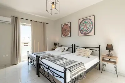 two beds in a bedroom with a window at City Center Elite Suite in Rhodes Town