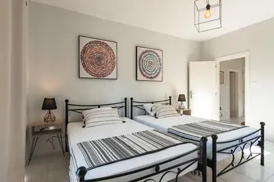 two beds in a bedroom with white walls at City Center Elite Suite in Rhodes Town