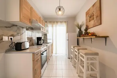 a kitchen with wooden cabinets and a white refrigerator at City Center Elite Suite in Rhodes Town