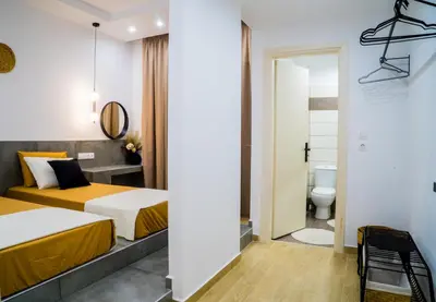 a hotel room with two beds and a toilet at Mousiko in Faliraki