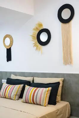 a bed with pillows and decorations on a wall at Mousiko in Faliraki