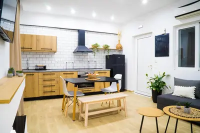 a kitchen and living room with a table and chairs at Mousiko in Faliraki