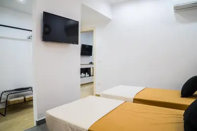 a room with two beds and a flat screen tv at Orama in Faliraki