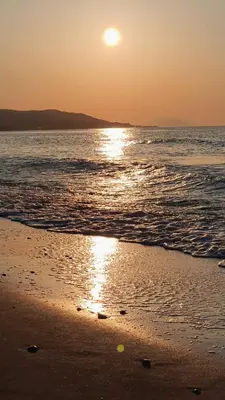a sunset on the beach with the sun setting at FANES HOUSE in Phanaes