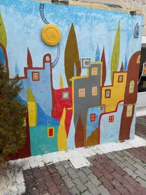 a wall with a mural of a city with a frisbee at FANES HOUSE in Phanaes