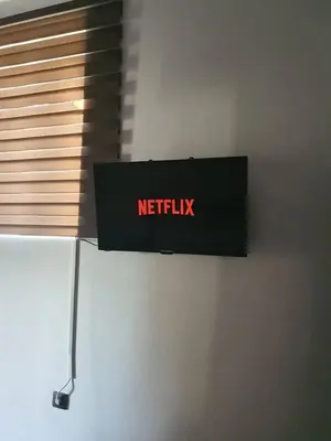 a netflix sign hanging on a wall next to a window at FANES HOUSE in Phanaes
