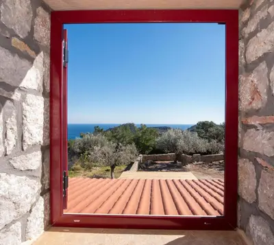 a red door with a view of the ocean at Sea Rock Villa Rodos in Archangelos