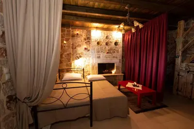 a bedroom with a bed and a red curtain at Sea Rock Villa Rodos in Archangelos