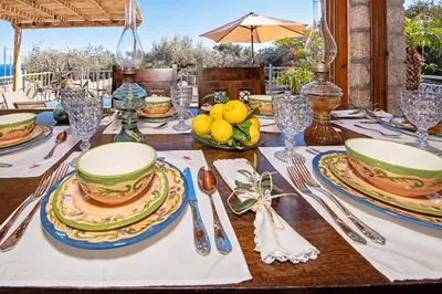 a table with plates and utensils on top of it at Sea Rock Villa Rodos in Archangelos