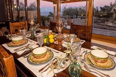 a dining room table with plates and dishes on it at Sea Rock Villa Rodos in Archangelos