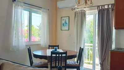 a dining room with a table and chairs and windows at Marilen in Livadia