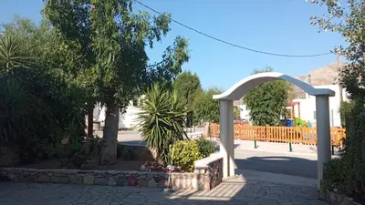 a white archway in a park with trees at Marilen in Livadia