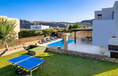 a backyard with a ping pong table and a pool at Adore Lindos Villa in Líndos