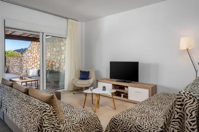 a living room with a couch and a television at Adore Lindos Villa in Líndos