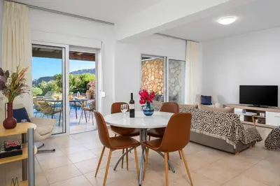 a living room with a table and chairs and a couch at Adore Lindos Villa in Líndos