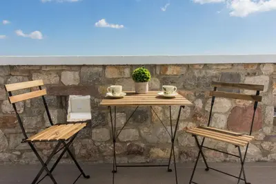 a table with two chairs and a table with a plant at Roccia di Isidoro in Áyios Isídhoros